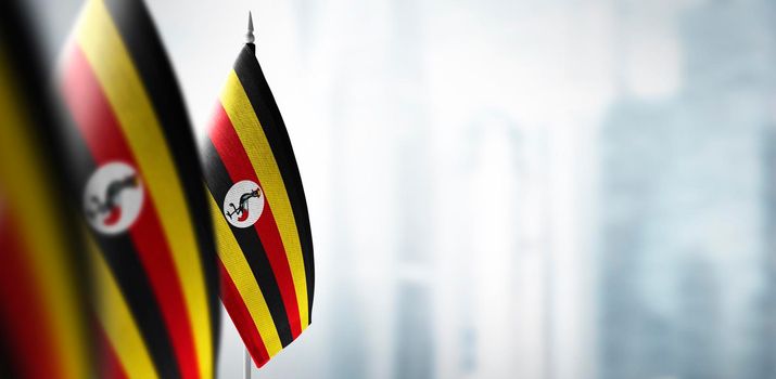 Small flags of Uganda on a blurry background of the city.