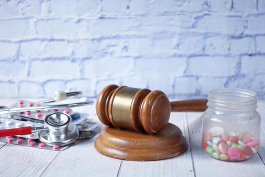 gavel, stethoscope and pills on white background.