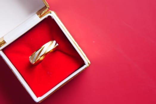 wedding ring in a box on red background