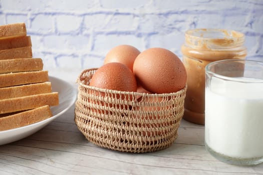 eggs in a bow and a glass of milk on table ,