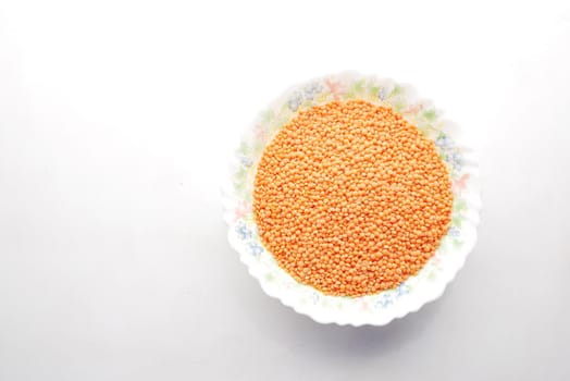 Bowl of uncooked dhal on white