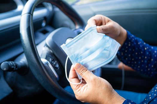 New Normal, Asian working woman holding face mask for protect safety Coronavirus in car.