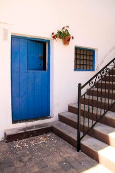 Typical Andalusian whitewashed facade with blue painted wooden door in Mojacar