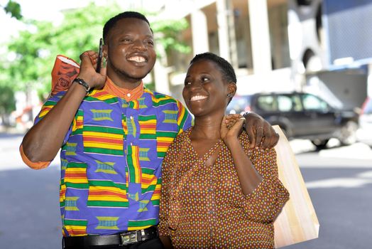 young african couple standing in shirt side by side laughing.