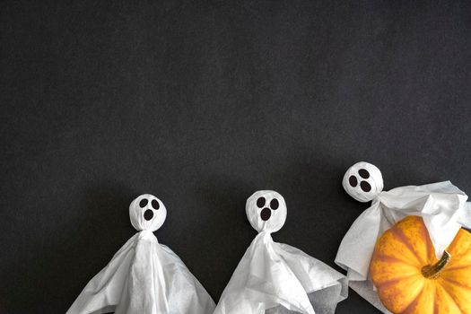 Two ghosts. pumpkin on black background, top view. Copy space. Halloween Concept.