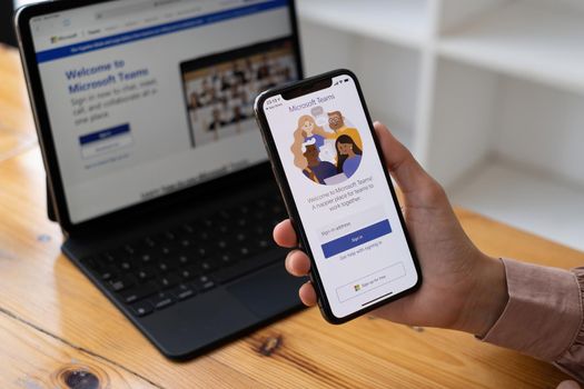 CHIANG MAI, THAILAND - SEP 29, 2021 : A working from home employee is downloading the Microsoft Teams social platform, ready for remote working in isolation from home