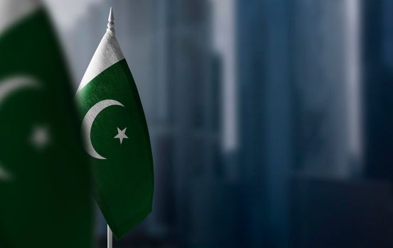 Small flags of Pakistan on a blurry background of the city.