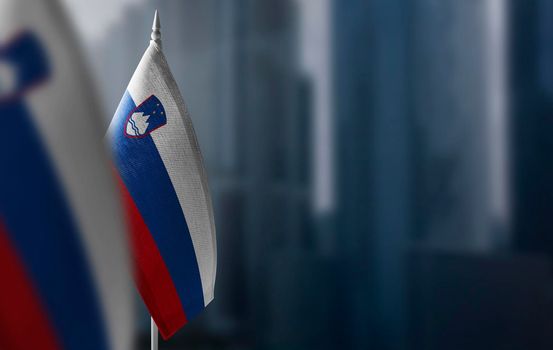 Small flags of Slovenia on a blurry background of the city.