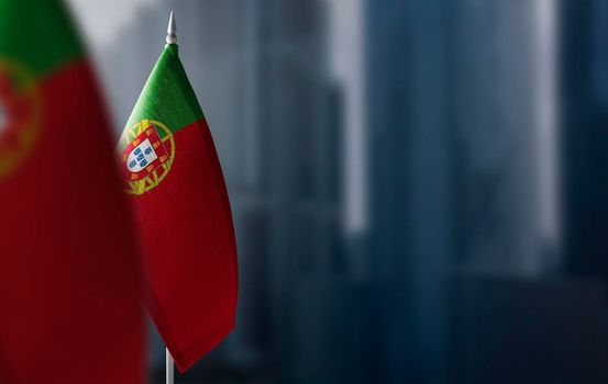 Small flags of Portugal on a blurry background of the city.
