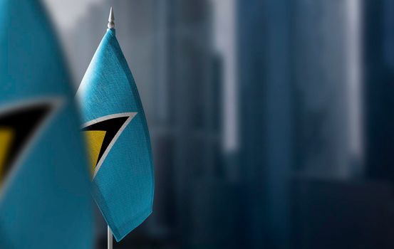 Small flags of Saint Lucia on a blurry background of the city.