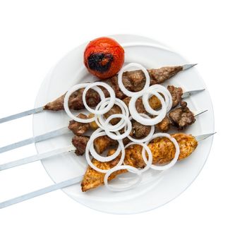 Kebab on skewers in a plate on a white background. Top view. Isolated. Barbecue