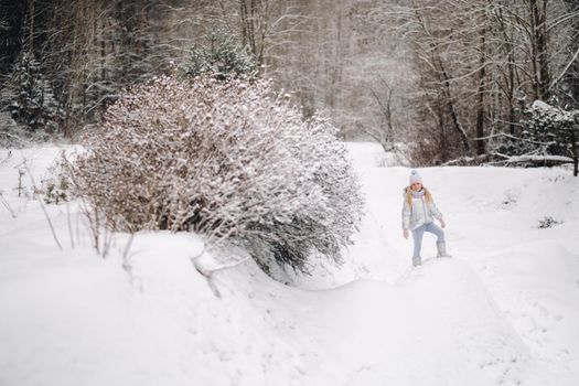 a little girl in a silver jacket in winter goes outside in winter.