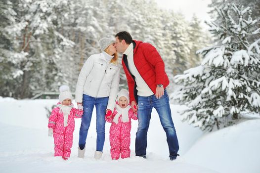 A large family with children on a walk in winter in the forest.