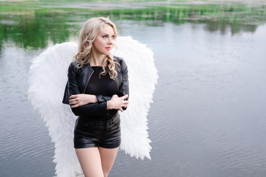 fallen angel. girl in black with white angel wings