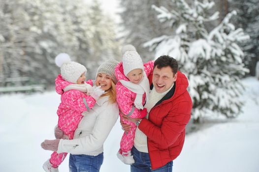 A large family with children on a walk in winter in the forest.