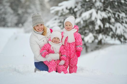 Mom and children on a walk in the winter in the forest.
