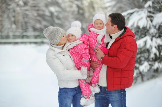 A large family with children on a walk in winter in the forest.