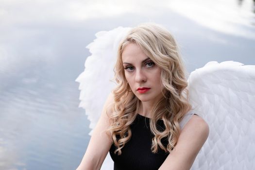 fallen angel. girl in black with white angel wings