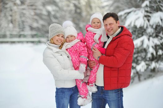 A large family with children on a walk in winter in the forest.