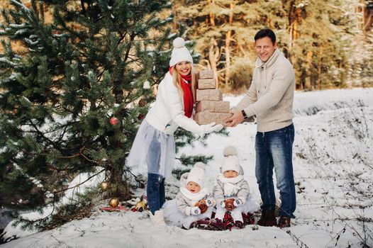 A large family with children at the Christmas tree on the street Happy Children with gifts.