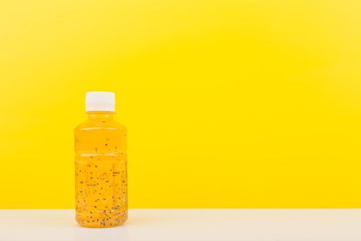 Detox drink or juice with chia seeds on white table against yellow background with copy space. Concept of healthy eating, dieting, weight loss and detox 