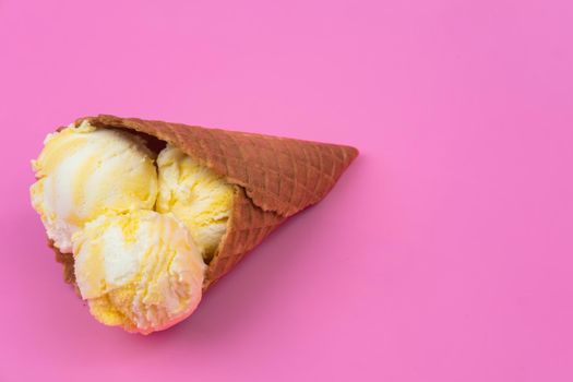 Fruit-scented ice cream balls in a waffle cone on a pink background