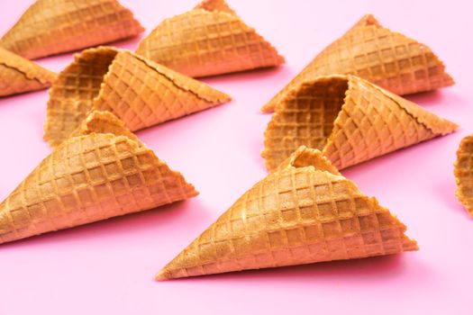 Waffle empty ice cream cones on a colored pink background.