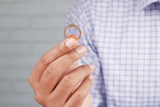 young man hold a wedding ring with copy space .
