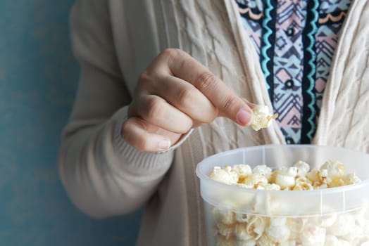 young women eating popcorn close up .