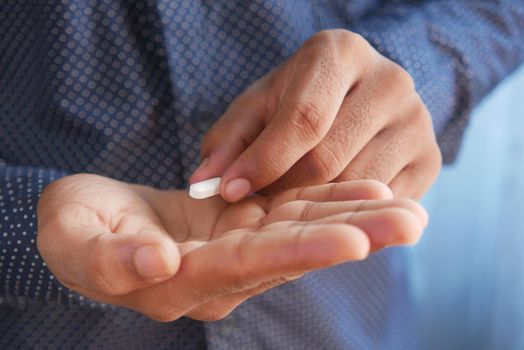 Close up of man hand holding pills with copy space .
