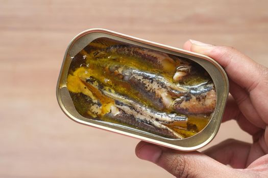 open tin of sardines on white tiles background