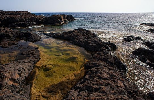 View of the scenic lava rock cliff in the Linosa island. Sicily