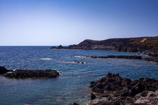 View of the scenic lava rock cliff in the Linosa island. Sicily