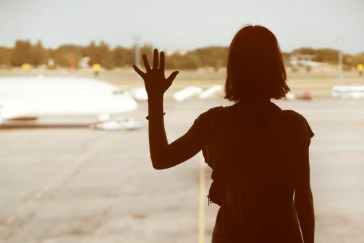 A young girl at the airport is boarding a plane at sunset, a woman goes on a journey.