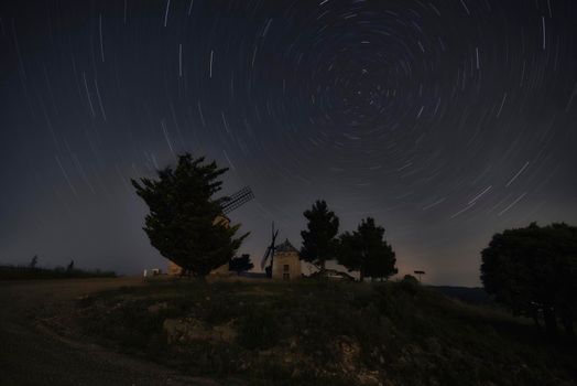 Circumpolar on windmills. Night photography, trees star trails