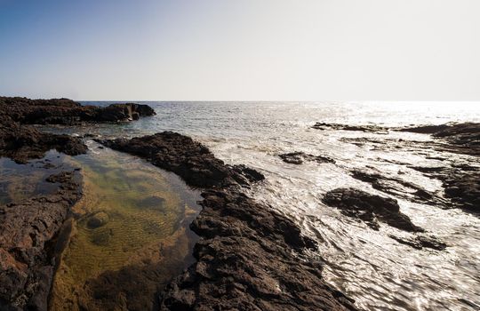 View of the scenic lava rock cliff in the Linosa island. Sicily