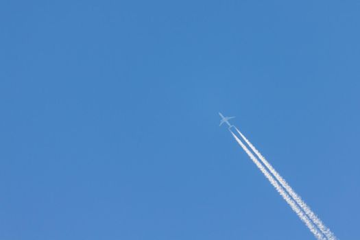 Flying plane leaves an inversion trail in the air. White and blue . nice logo