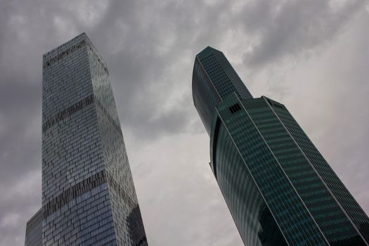 Tall buildings skyscrapers against the clouded sky. Concrete and glass High quality photo