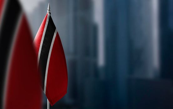 Small flags of Trinidad and Tobago on a blurry background of the city.
