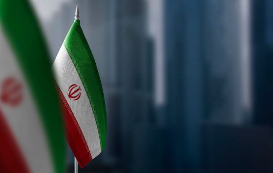 Small flags of Iran on a blurry background of the city.