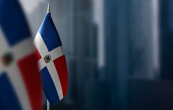 Small flags of Dominicana on a blurry background of the city.