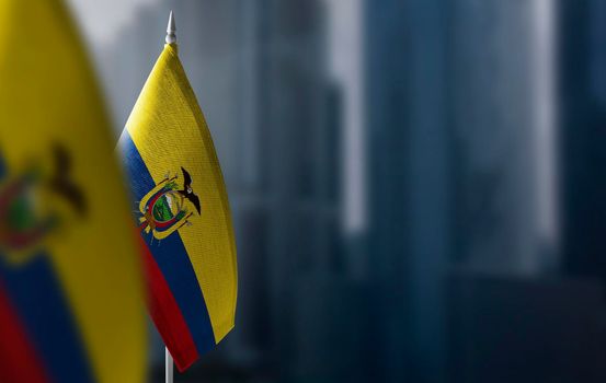 Small flags of Ecuador on a blurry background of the city.