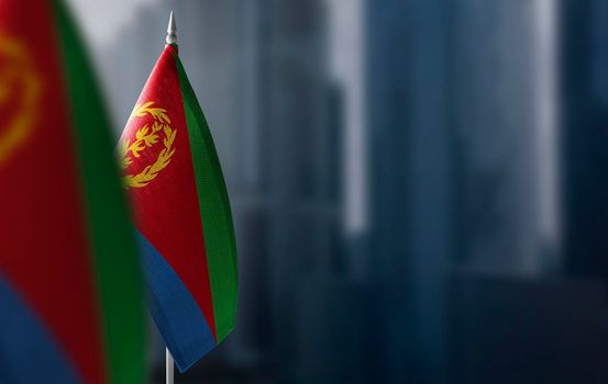 Small flags of Eritrea on a blurry background of the city.