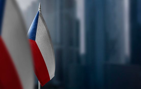 Small flags of Czechia on a blurry background of the city.
