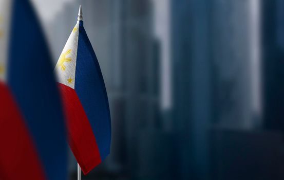 Small flags of Philippines on a blurry background of the city.
