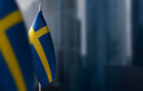 Small flags of Sweden on a blurry background of the city.