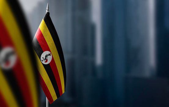 Small flags of Uganda on a blurry background of the city.