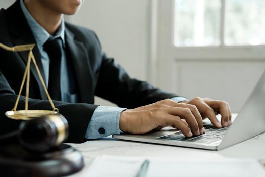 Law, legal services, advice, justice and law concept. Male lawyer in the office with brass scale. 
