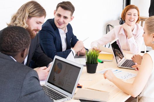 Confident businessmen and businesswomen sitting and working. Business people sitting around the desk in a meeting