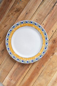A ceramic dish (plate) on wooden table.Flat lay